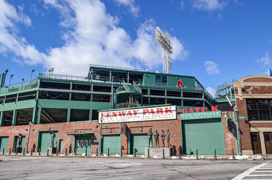 Iconic Fenway Park entrance on a clear day in Boston, showcasing historic architecture and vibrant atmosphere.